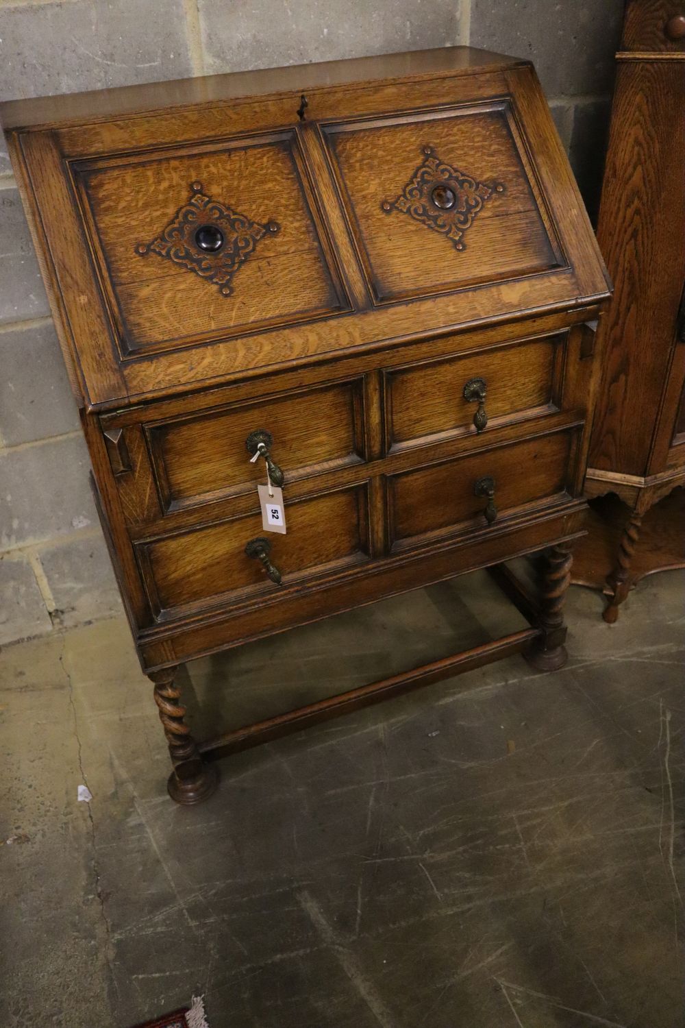 A 1920s panelled oak bureau, width 74cm, depth 46cm, height 103cm, together with a similar standing corner cabinet